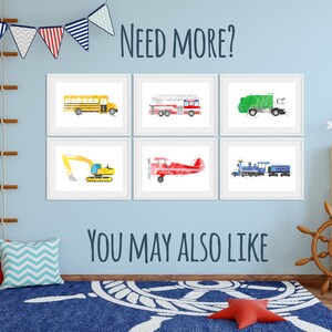 May include: A set of six framed watercolor illustrations of various vehicles, including a school bus, fire truck, garbage truck, excavator, airplane, and train. The illustrations are displayed on a light blue wall in a child's room.