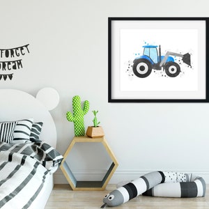 May include: A watercolor painting of a blue tractor with a black and white design. The tractor is on a white background with black splatters of paint. The painting is framed in a black frame and is hanging on a white wall.