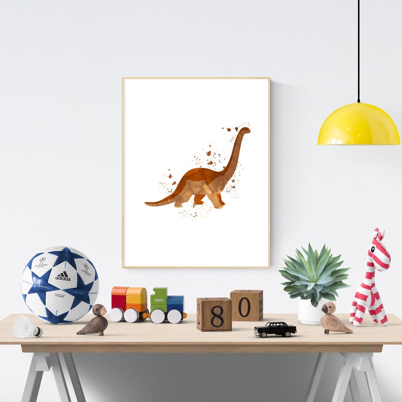 May include: A watercolor painting of a brown dinosaur on a white background. The dinosaur is in a standing position with its neck arched. The painting is framed and hanging on a white wall. There are wooden blocks with the numbers 8 and 0 on the table below the painting.
