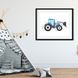 May include: A blue and black watercolor illustration of a tractor with a bucket, framed in a black frame. The image is hanging on a white wall in a nursery.