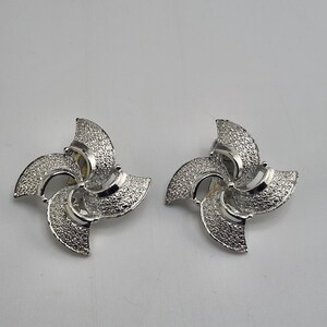 Pendientes de clip vintage con forma de rueda de molino en tono plateado