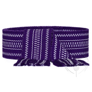 May include: A woven purple belt with white horizontal and vertical stripe patterns. The belt has a fringed end. The belt is shown on a white background.