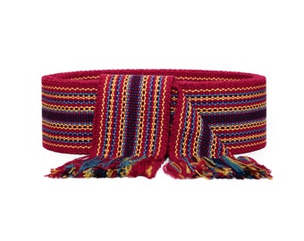 May include: A red, blue, and yellow woven belt with fringe tassels. The belt is made of a thick, textured fabric and has a geometric pattern.