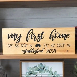May include: A wooden sign with the text "my first home" and coordinates "39° 56' 17.4" N 76° 42' 53.3" W" and the text "established 2021".