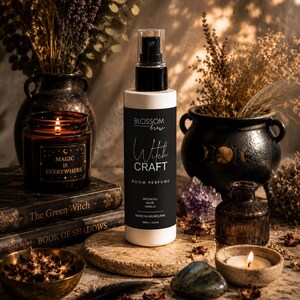 May include: A white cylindrical room perfume spray bottle with a black label featuring the text Blossom Brew Witch Craft Room Perfume, Patchouli Musk Vanilla, Made in Melbourne, 100ml, 3.3 oz, topped with a black pump sprayer and clear cap.