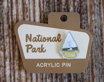May include: A brown card with the text "National Park" and "Acrylic Pin" on it. A clear acrylic pin with a white mountain and the text "Yellowstone National Park" is attached to the card.