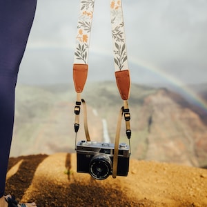 women holding wildflower camera strap attached to vintage camera overlooking the canyon.