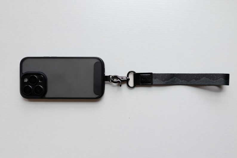 midnight mountain black keychain. Printed with mountains and stars attached to phone