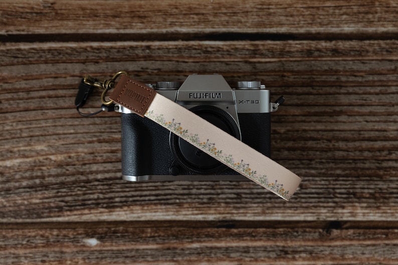 Floral printed keychain. small dainty flowers on tan strap attached to light weight camera