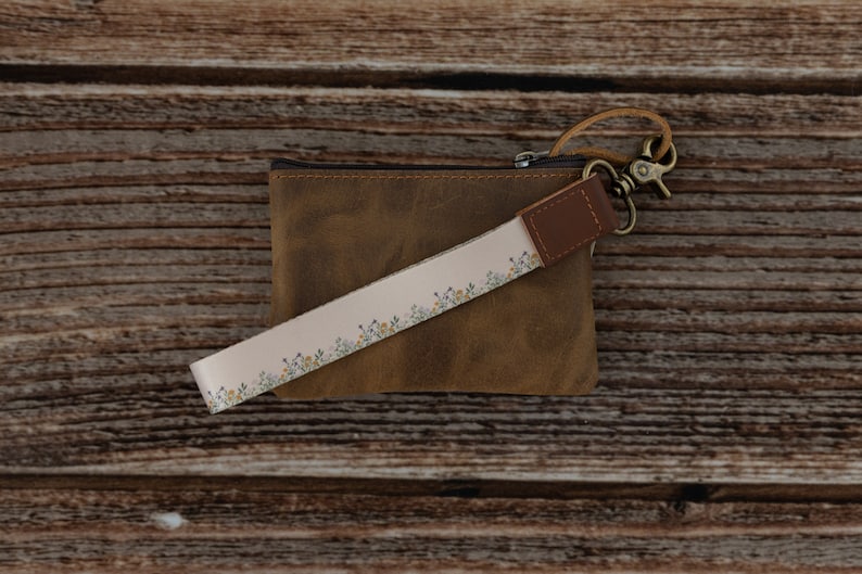 flower printed keychain attached to brown leather coin pouch