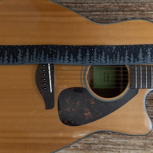 black guitar strap with printed trees and stars