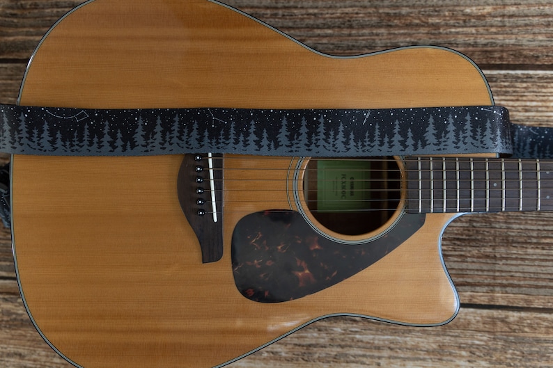 black guitar strap with printed trees and stars