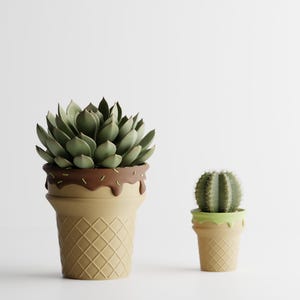 May include: Two decorative planters shaped like ice cream cones. One holds a green succulent, the other a small cactus. The larger planter has a brown chocolate-like drip design. The smaller planter has a green drip design.