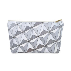 Può includere: Una pochette con cerniera a motivo geometrico bianco e grigio. Il motivo ricorda una cupola geodetica.