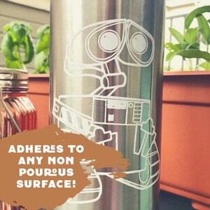 May include: A stainless steel water bottle with a white vinyl decal of the robot character WALL-E from the Disney Pixar movie WALL-E. The text "ADHERES TO ANY NON POROUS SURFACE!" is on the bottle.