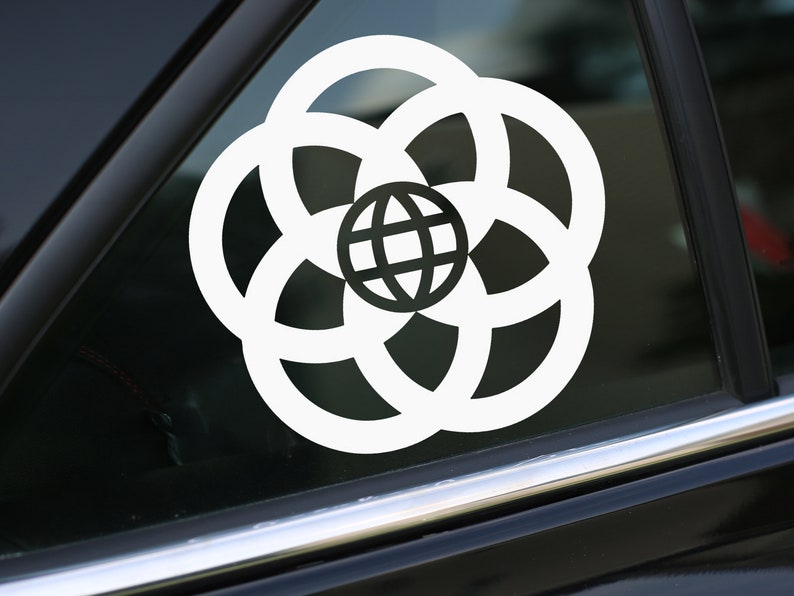 May include: White vinyl sticker of the Epcot logo, featuring a globe surrounded by four rings, on a black car window.