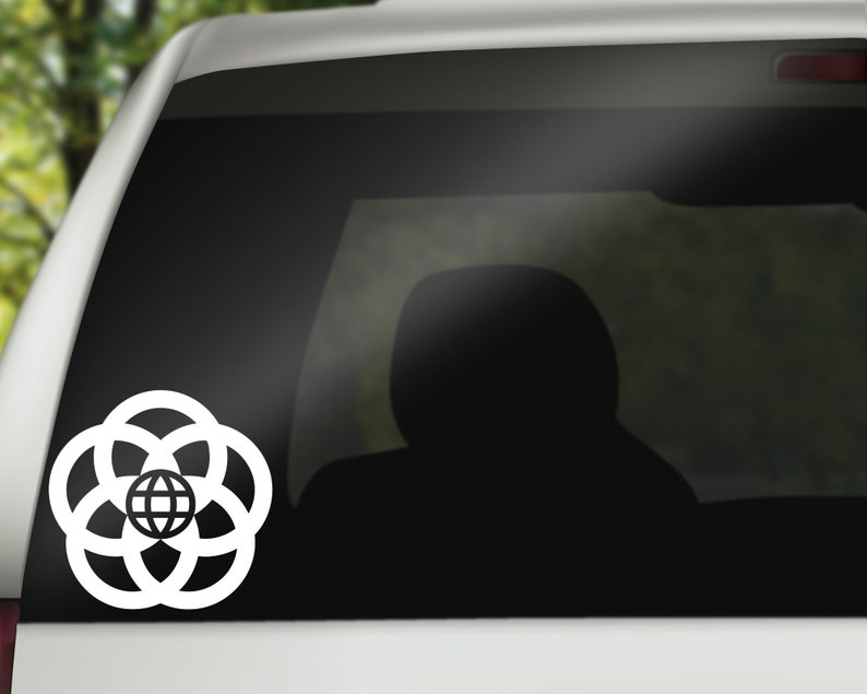 May include: White vinyl decal of the Epcot logo, featuring a globe surrounded by four rings, on a black car window.