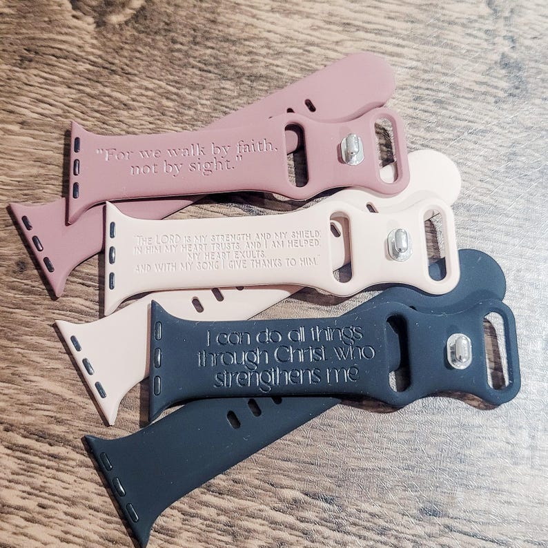 Puede incluir: Cuatro correas de reloj diferentes con citas inspiradoras. Las correas son de color negro, rosa y beige. Las citas son "Porque por fe andamos, no por vista", "El Se&ntilde;or es mi fortaleza y mi escudo, en &eacute;l conf&iacute;a mi coraz&oacute;n, y soy ayudado, mi coraz&oacute;n se regocija, y con mi canto le doy gracias", y "Todo lo puedo en Cristo que me fortalece".