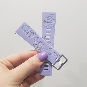 Puede incluir: Dos correas de reloj de silicona lavanda con un dise&ntilde;o de Winnie the Pooh. Las correas tienen una hebilla plateada.