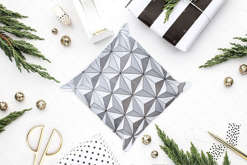 K&ouml;nnte beinhalten: Eine wei&szlig;e Geschenkt&uuml;te mit einem geometrischen Muster in Graut&ouml;nen. Die T&uuml;te liegt flach auf einer wei&szlig;en Oberfl&auml;che mit dekorativen Gegenst&auml;nden drumherum.