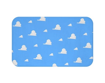 May include: A blue bath mat with a white cloud pattern. The clouds are arranged in a repeating pattern across the mat.