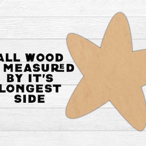 K&ouml;nnte beinhalten: Eine hellbraune Holzsternform auf wei&szlig;em Holzmaserungshintergrund. Der Text "ALL WOOD IS MEASURED BY IT'S LONGEST SIDE" ist schwarz gedruckt. Der Stern ist ein Bastelbedarf.