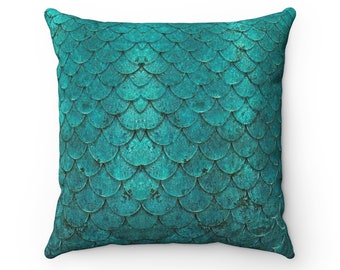 May include: Teal blue throw pillow with a mermaid scale pattern.