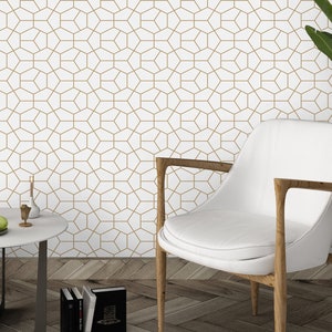 Puede incluir: Papel tapiz con un patrón geométrico repetitivo de líneas doradas finas que forman hexágonos y pentágonos interconectados sobre un fondo blanco. El diseño crea un efecto visual estructurado similar a una cuadrícula.
