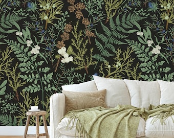 Puede incluir: Un sofá blanco con una manta verde y almohadas, colocado frente a un papel tapiz floral negro y verde con un diseño botánico.