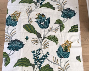 May include: White fabric with a repeating floral pattern. The design features teal and yellow flowers, green leaves, and gray stems. The fabric is likely used for upholstery or home decor.