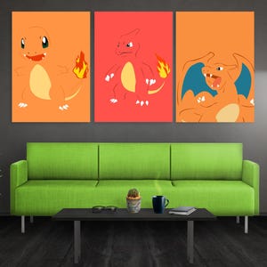 May include: A set of three rectangular wall art prints featuring stylized orange and red cartoon creatures with flame-tipped tails and blue wings. The first print shows a smiling creature, the second a standing figure, and the third a roaring beast.