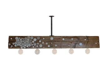May include: A rustic wooden chandelier with a metal canopy and five light bulbs. The wood is dark brown and has a distressed finish. The chandelier is decorated with a pattern of silver circles.