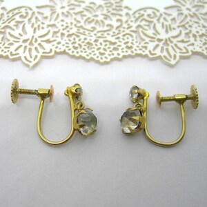 May include: A pair of gold tone clip-on earrings with clear faceted stones.