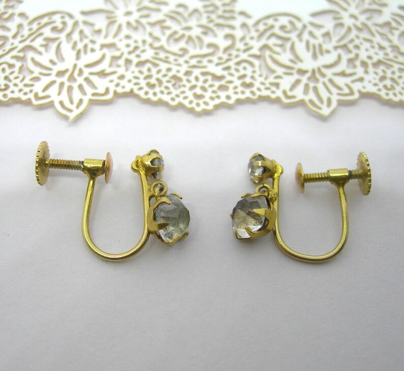 May include: A pair of gold tone clip-on earrings with clear faceted stones.