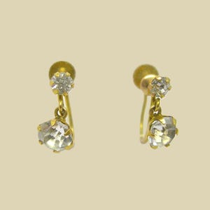 May include: A pair of gold earrings with two clear crystal stones on each earring.