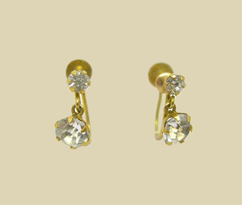 May include: A pair of gold earrings with two clear crystal stones on each earring.