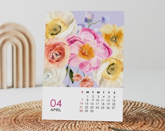 May include: A desk calendar page for April featuring a watercolor floral illustration with pink, yellow, and white flowers against a light purple background. The calendar grid displays the month number 04, the text APRIL, and the days of the month.