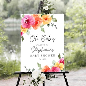 May include: A white sign with watercolour flowers in shades of pink, orange, and yellow. The sign reads "Oh Baby" and "Welcome to Stephanie's Baby Shower 04.15.23".