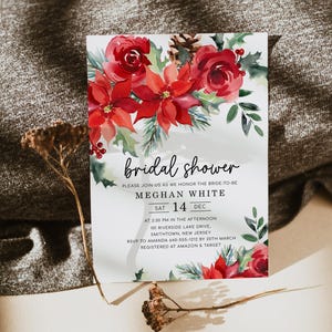 Op de afbeelding: Een witte bruidsdouche-uitnodiging met een aquarelontwerp van rode kerststerren en rozen. De tekst luidt "bridal shower", "Please join us as we honor the bride-to-be", "Meghan White", "Sat 14 Dec", "At 2:30 PM in the afternoon", "101 Riverside Lake Drive, Smithtown, New Jersey", "RSVP to Amanda 640-555-1212 by 20th March", "Registered at Amazon & Target".