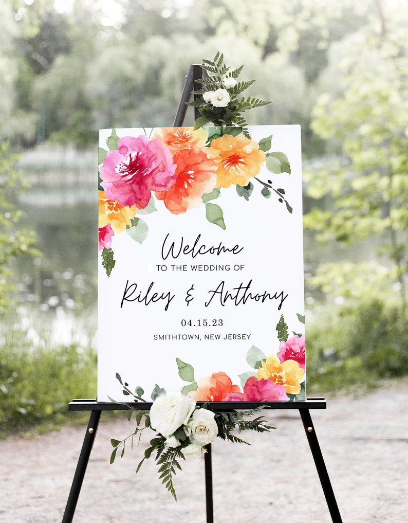Pode incluir: Bem-vindos ao casamento de Riley & Anthony, um cartaz de casamento com flores de aquarela em tons de rosa, laranja e amarelo. A data &eacute; 04.15.23 e o local &eacute; Smithtown, New Jersey.