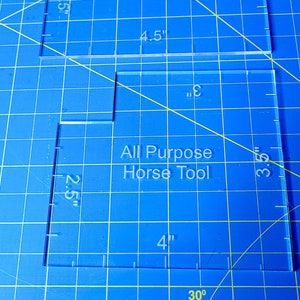 May include: Two clear plastic rulers with the text "All Purpose Horse Tool" printed on them. The rulers are marked with inches and have measurements of 2.5 inches, 3 inches, 3.5 inches, 4 inches, and 4.5 inches.