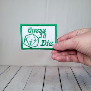 May include: Green and white embroidered patch with a dice and the text "Guess 'til Die".