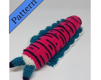 May include: A crocheted pink and black sea slug with teal blue tentacles. The sea slug is lying on a white and teal crocheted blanket.
