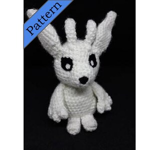 May include: White crocheted plush toy resembling a creature with large ears, black eyes, and a small black nose.