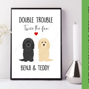 May include: A white printable art print with black text that reads "Double Trouble Twice the Fun" with a red heart in between the words. Two cartoon dogs are below the text, one black and one light brown. The names "Benji & Teddy" are below the dogs.