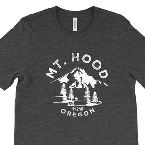 May include: A dark heather grey t-shirt with a white graphic of Mount Hood, Oregon. The graphic includes the mountain, trees, and the text "MT. HOOD 11,240' OREGON".
