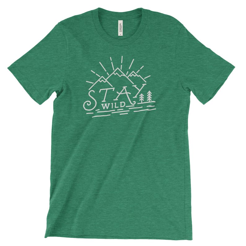 May include: A green t-shirt with a white graphic design of mountains and trees. The text "Stay Wild" is written below the mountains.