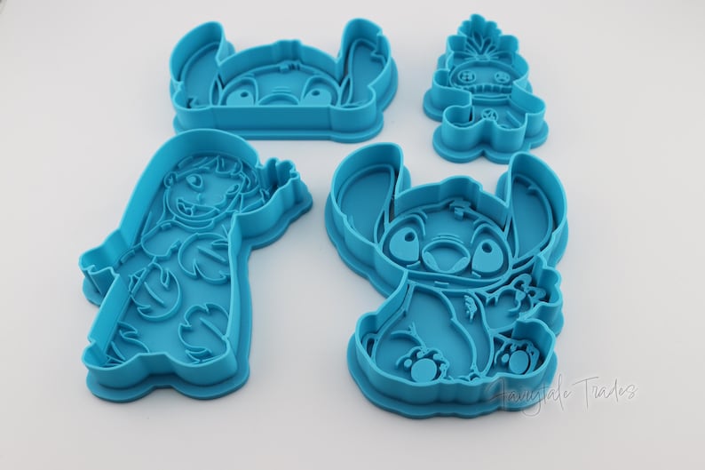May include: A collection of four blue plastic cookie cutters in various shapes, featuring characters from a popular animated film. The cutters include the character Stitch in different poses, and another character. Ideal for baking themed treats.