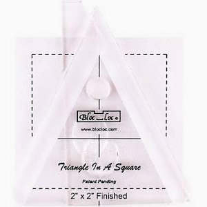 May include: A clear acrylic quilting ruler with a triangle shape inside a square. The ruler has black markings, the "Bloc Loc" logo, and the text "Triangle In A Square". It measures 2" x 2" when finished.
