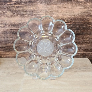 Peut inclure: Un plat de service en verre transparent avec un bord festonné et un motif floral givré au centre. Le plat comporte 12 sections individuelles.